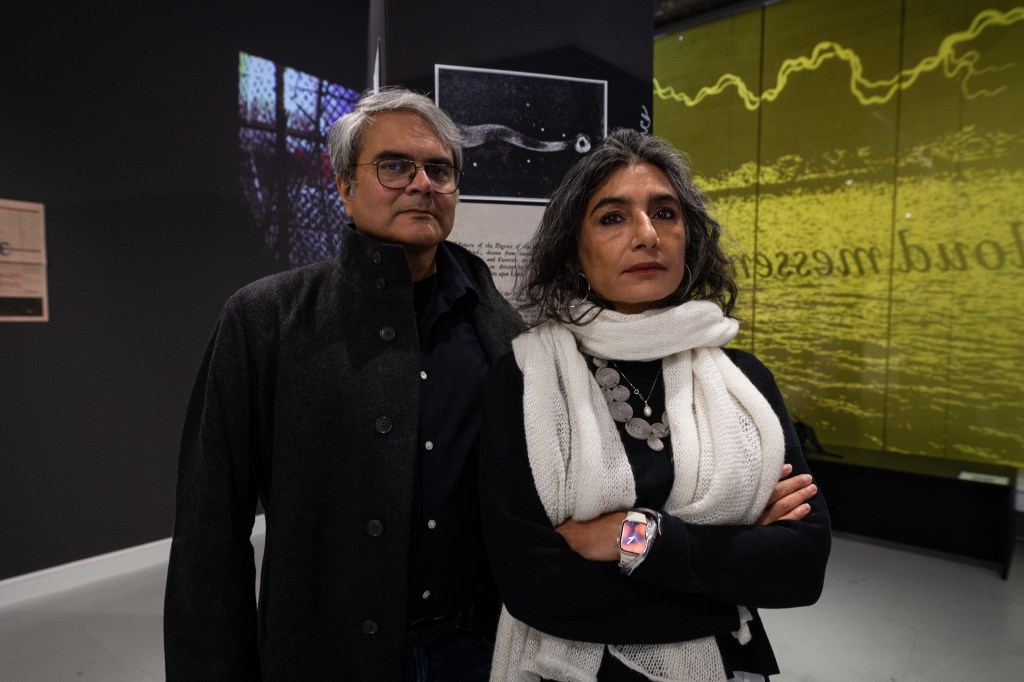 portrait of Monica Narula and Shuddha Sendupta of Raqs Media Collective with artwork in the background